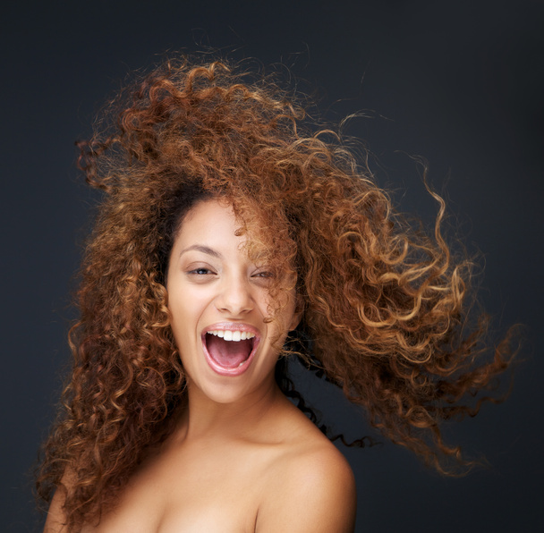 Portrait of a fun and happy young woman laughing with hair blowing - Photo, Image
