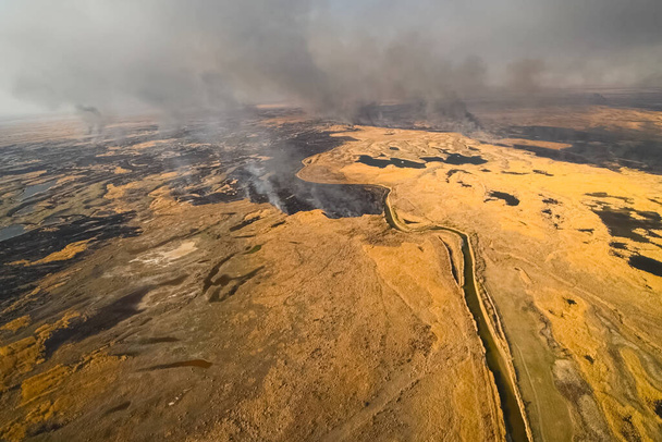 Tundra yangını. Kuru otları ve turba bataklıklarını yakmak, tundrada ateş ve duman çıkarmak. - Fotoğraf, Görsel