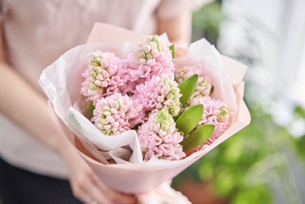 Joven mujer feliz sosteniendo un hermoso ramo de jacintos rosados en sus manos. Un regalo para una chica sonriente. Ramo de flores
. - Foto, Imagen