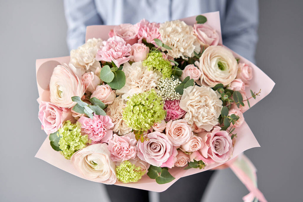 European floral shop. Beautiful bouquet of mixed flowers in womans hands. the work of the florist at a flower shop. Delivery fresh cut flower. - Фото, изображение