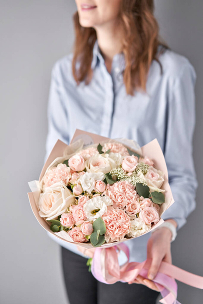 European floral shop. Beautiful bouquet of mixed flowers in womans hands. the work of the florist at a flower shop. Delivery fresh cut flower. - Фото, зображення