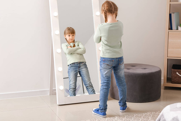 Grappig klein meisje kijken in spiegel thuis - Foto, afbeelding