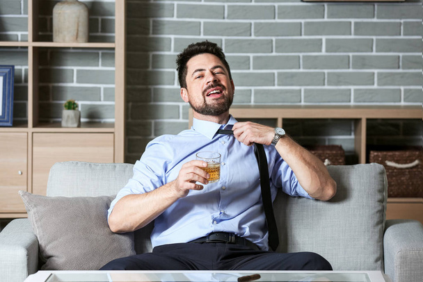 Бизнесмен пьет виски дома. Концепция алкоголизма
 - Фото, изображение