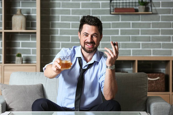 Бизнесмен с виски и сигарой дома. Концепция алкоголизма
 - Фото, изображение
