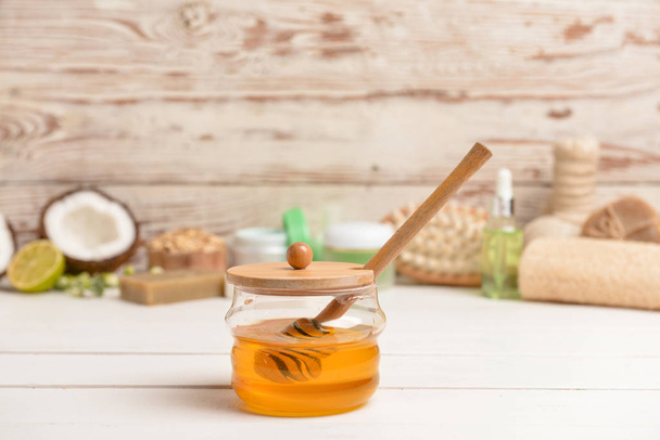Jar with sweet honey and spa items on table - Fotoğraf, Görsel