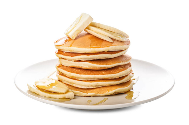 Lekkere pannenkoeken met honing, boter en banaan op witte achtergrond - Foto, afbeelding