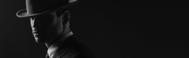Monochrome afbeelding van mafioso met vilten hoed geïsoleerd op zwart, panoramisch schot - Foto, afbeelding