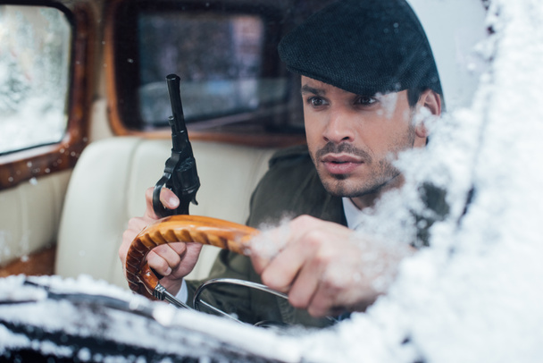 Selective focus of dangerous mafioso with weapon driving car - Foto, imagen