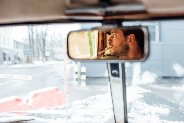 Focus selettivo del riflesso mafioso nello specchio retrovisore fumante in auto
 - Foto, immagini