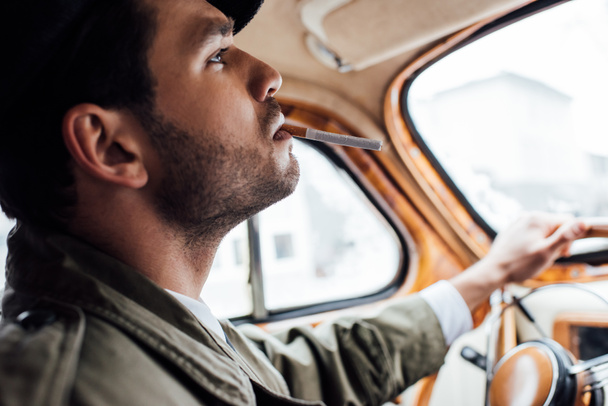 Επιλεκτική εστίαση του καπνίσματος μαφιόζου και της συγκράτησης του τιμονιού στο αυτοκίνητο - Φωτογραφία, εικόνα