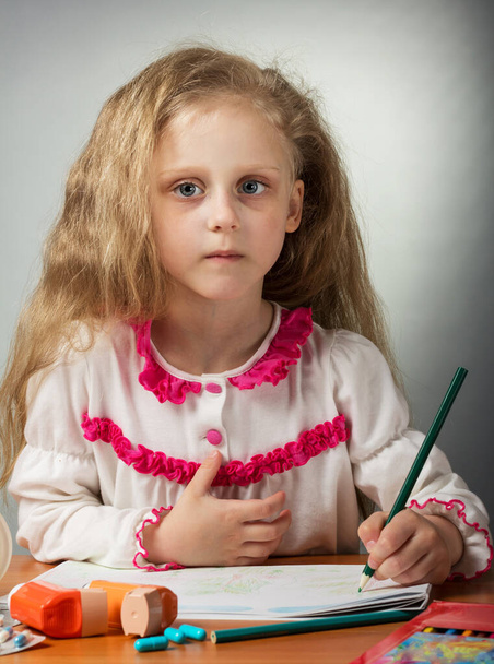 Little sick girl draws in album, near on table inhaler and capsules - Foto, imagen