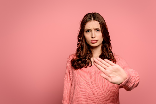 disgustado chica mostrando stop gesto mientras mira a la cámara aislada en rosa
 - Foto, Imagen