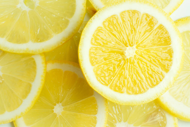 Background from bright juicy sliced lemon slices. - Foto, Bild