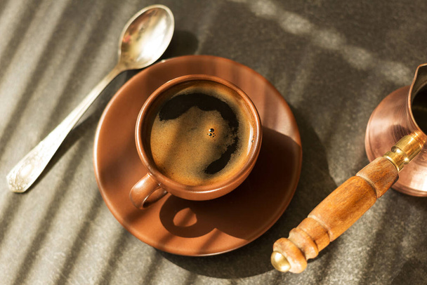Coffee-maker, Cup of fragrant morning coffee and a spoon on table - Foto, Imagem