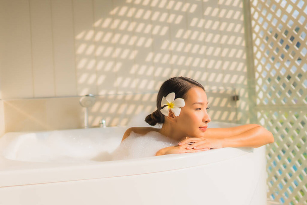 Portret jonge aziatische vrouw ontspannen nemen een bad in bad voor spa concept - Foto, afbeelding