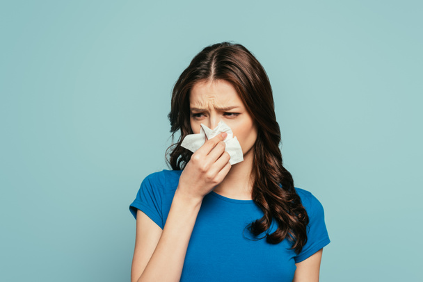 chica enferma, disgustada limpiando la nariz con servilleta de papel aislada en azul
 - Foto, Imagen