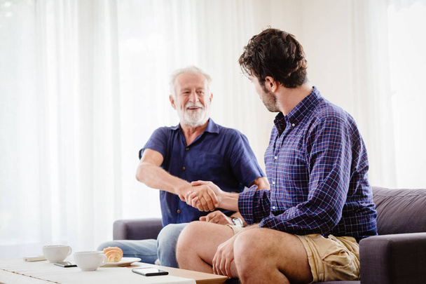 elder hand shaking dealing with a man indoor shot - Photo, Image