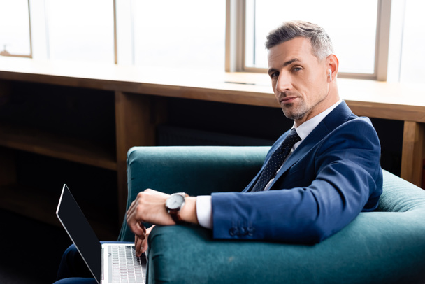 businessman in suit with earphones and laptop looking at camera  - Foto, imagen