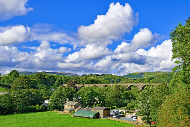 Ingleton ist ein Dorf und eine zivile Gemeinde im Bezirk Craven in North Yorkshire, England. Das Dorf liegt 19 Meilen von Kendal, 17 Meilen von Lancaster entfernt, westlich der Pennines und umfasst Wasserfallwege und berühmte Ausblicke auf die drei Gipfel. - Foto, Bild