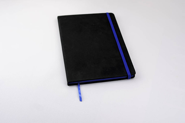 Κλειστό μαύρο δερμάτινο ημερολόγιο με μπλε φινίρισμα και διαχωριστικό για mockup ως προϊόν merchandising - Φωτογραφία, εικόνα