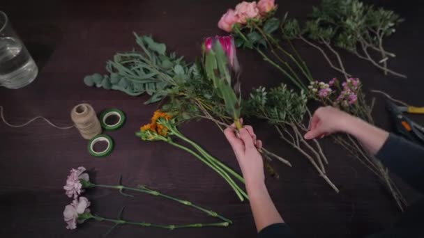 flower shop, professional florist female prepares flowers to bouquet for sale in floristic studio, floral business concept - 映像、動画