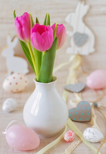 mooie paastafel decoratie met eieren, konijnen en bloemen in pastelkleuren - Foto, afbeelding