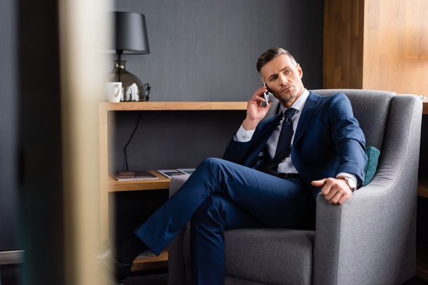selective focus of businessman in suit talking on smartphone  - Фото, изображение