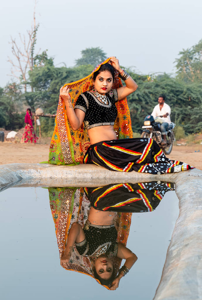 Puşkar, Rajasthan / Hindistan - Kasım 2019: Etnik rajasthani elbisesi içindeki güzel Hintli genç bir kadının portresi - Fotoğraf, Görsel