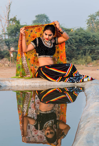 Pushkar, Rajasthan / India - november 2019: Portret van jonge Indiaanse mooie vrouw in etnische rajasthani jurk genietend van de cultuur en fair of pushkar - Foto, afbeelding
