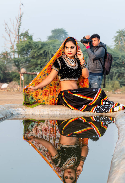 Pushkar, Rajasthan / India - listopad 2019: Portret młodej hinduskiej pięknej kobiety w etnicznej sukience rajasthani cieszącej się kulturą i targiem pushkar - Zdjęcie, obraz
