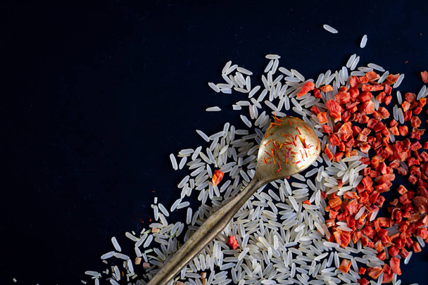 rice with spices on a dark background, saffron, metal spoo - Фото, зображення