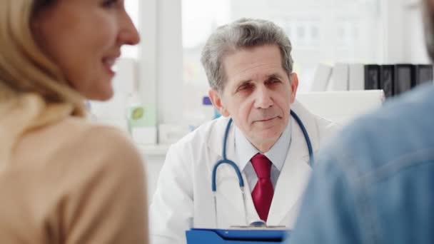 Ręczny widok pary rozmawiającej z lekarzem w gabinecie lekarskim. Nakręcony aparatem hel RED w rozdzielczości 8K - Materiał filmowy, wideo