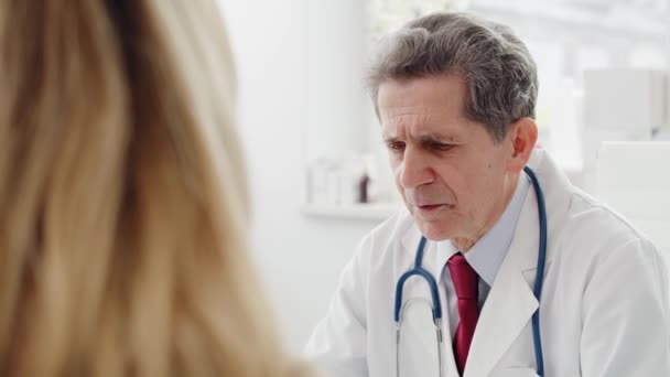 Podręczny widok lekarza rozmawiającego z pacjentami. Nakręcony aparatem hel RED w rozdzielczości 8K   - Materiał filmowy, wideo