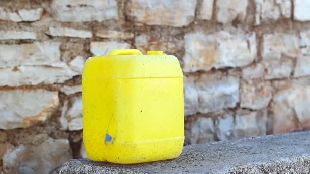 Big yellow canister on bench near stoned wall. For water. Oil. Fuel. Or just a forgotten trash. - Séquence, vidéo
