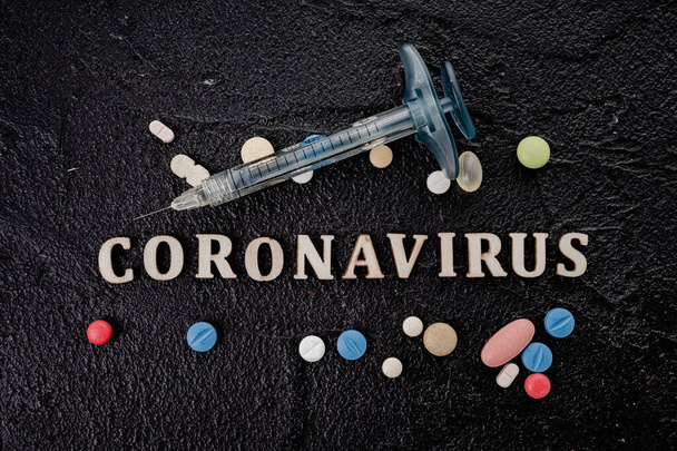 Coronavirus vaccine vial with injection syringe isolated on black background - Foto, Imagen