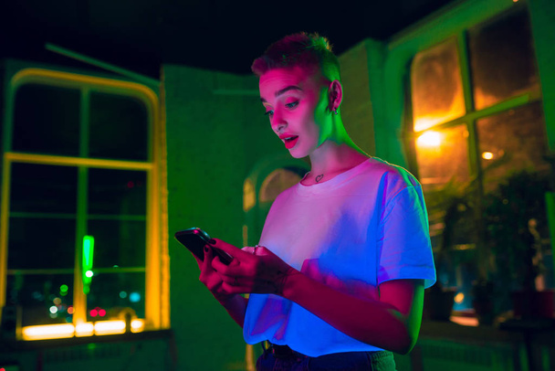 Cinematic portrait of handsome young woman in neon lighted interior - Фото, зображення