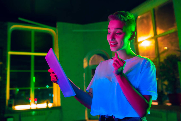 Cinematic portrait of handsome young woman in neon lighted interior - Fotó, kép