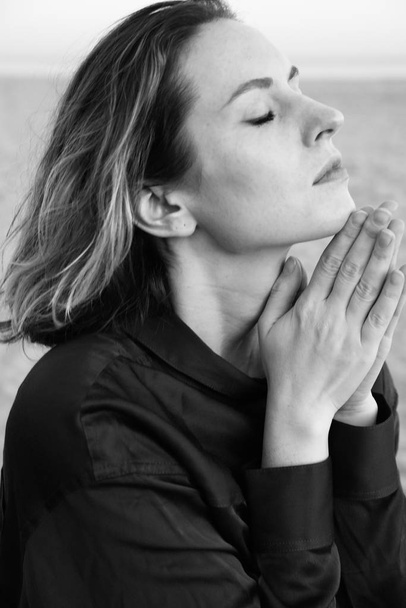 Молодая женщина медитирует на пляже. Черно-белое фото
. - Фото, изображение