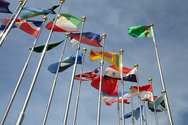 Bandeiras de diferentes países unidas contra o céu azul
 - Foto, Imagem