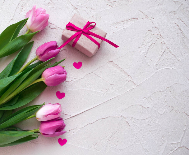 Beautiful spring tulips with hearts and gift box on grey stone background. Concept of Valentines day, Women's Day March eight, Mothers day. Space for text, flat lay. - Φωτογραφία, εικόνα