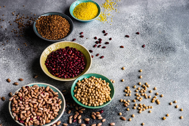 Концепция органических продуктов питания с сырыми зерновыми на каменном фоне с копировальным пространством
 - Фото, изображение