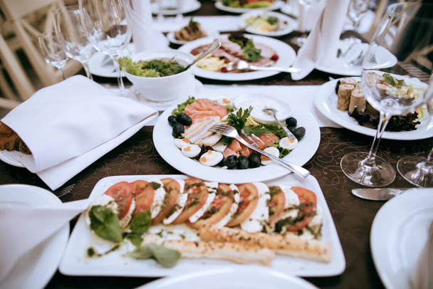 Teller mit Vorspeisen auf dem Tisch in einem Restaurant bei einer Party. Essen auf dem Tisch - Foto, Bild