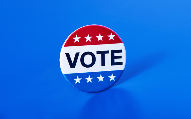 fechamento de um crachá de voto para as eleições dos Estados Unidos em um fundo azul
 - Foto, Imagem