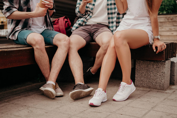 Students Travelers Drink Tea While Relaxing On A Bench In The City. - 写真・画像