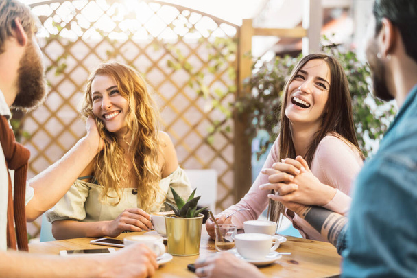 Szczęśliwi przyjaciele pijący cappuccino w barze kafeteryjnym - Młoda romantyczna para spędzająca wspólnie czas - Love relationship and social meeting people lifestyle concept - Zdjęcie, obraz