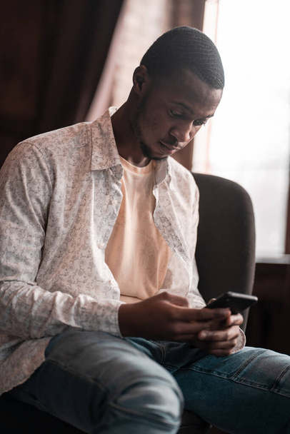 Smart Black Freelancer Is Chatting In His Smartphone - Fotografie, Obrázek
