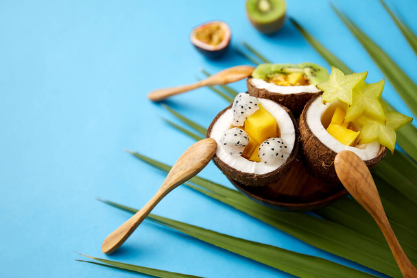mix of exotic fruits in coconut shells with spoons - Fotoğraf, Görsel