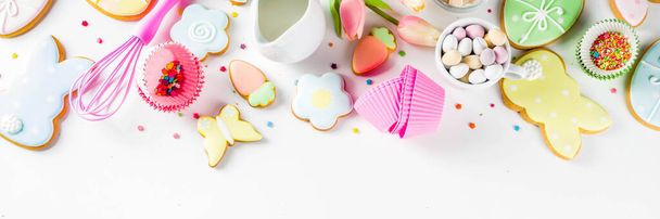 Sweet Easter baking cooking background with traditional Easter bunny and egg cookies, sugar sprinkles, ingredients, utensils. White table background copy space layout - Foto, Imagen