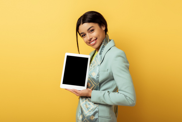 happy african american woman holding digital tablet with blank screen on yellow  - Fotografie, Obrázek
