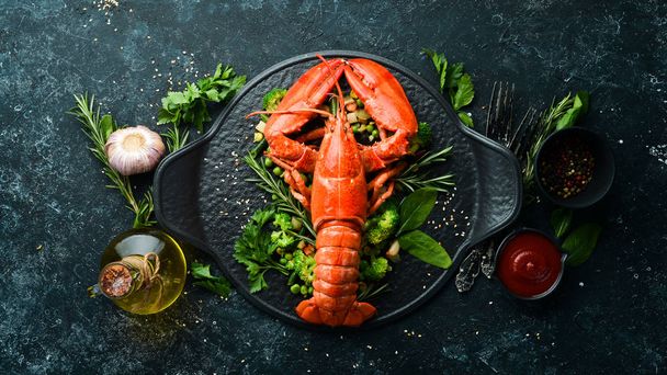 Boiled lobster with vegetables on a black stone plate. Seafood. Top view. Free space for your text. - Foto, Bild